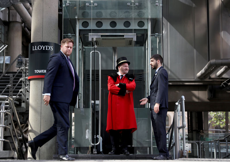 © Reuters. A doorman stands outside Lloyds of London's headquarters in the City of London