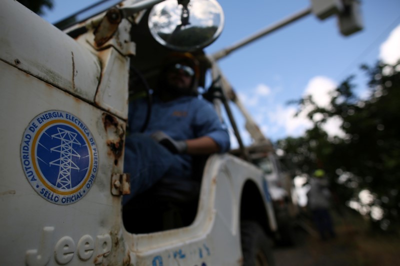 © Reuters. Workers of Puerto Rico's Electric Power Authority (PREPA) repair part of the electrical grid as the island's fragile power system is still reeling from the devastation wrought by Hurricane Maria eight months ago, in Utuado