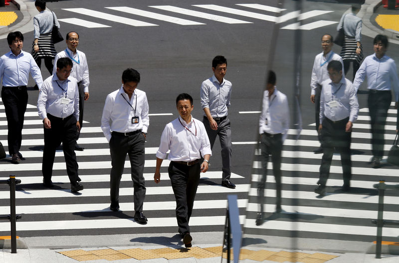 © Reuters. FILE PHOTO: Office workers are reflected in a glass railing as they cross street during lunch hour in Tokyo