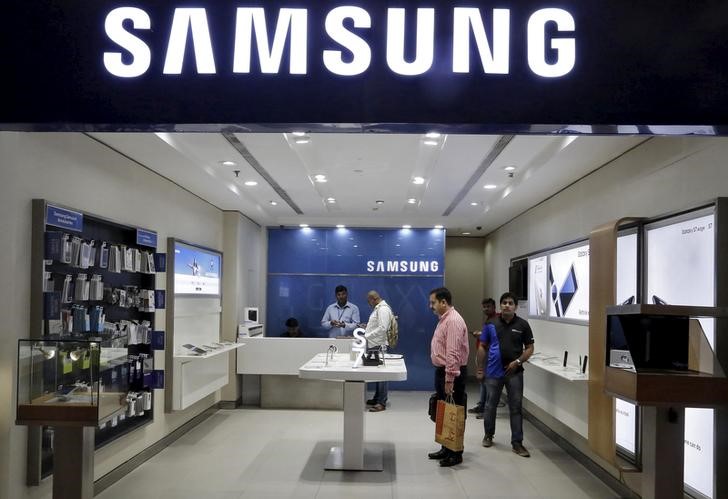 © Reuters. FILE PHOTO - Customers shop at a Samsung mobile store inside a shopping mall in New Delhi