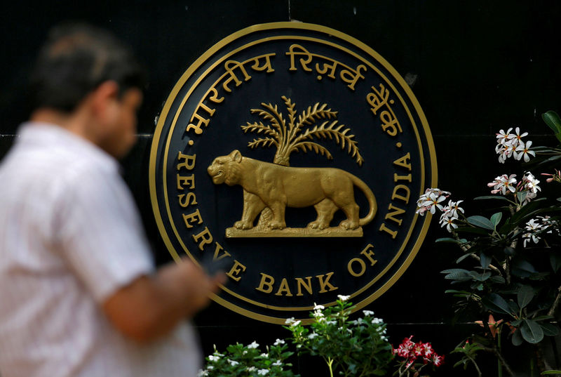 © Reuters. FILE PHOTO: A man checks his phone outside the RBI headquarters in Mumbai