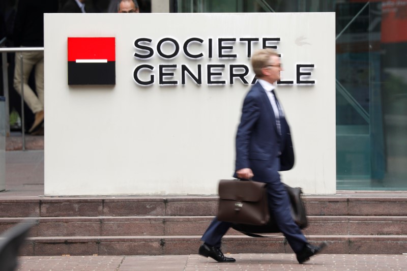 © Reuters. A man passes by the logo on the headquarters of French bank Societe Generale at the financial and business district of La Defense at Puteaux near Paris