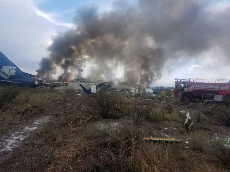 © Reuters. Firefighters douse a fire at the site where an Aeromexico-operated Embraer passenger jet crashed in Mexico's northern state of Durango