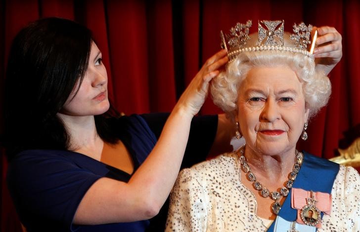 © Reuters. FILE PHOTO: Madame Tussauds employee Keeley Scothern poses with a new figure of Britan's Queen Elizabeth, produced in honour of her Diamond Jubilee in London