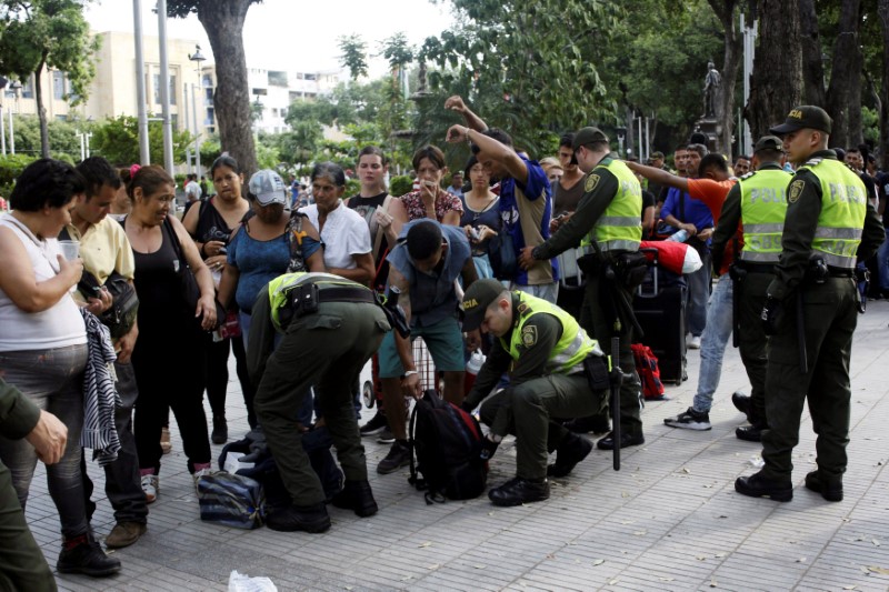 © Reuters. Policiais colombianos inspecionam bagagem de venezuelanos em Cúcuta