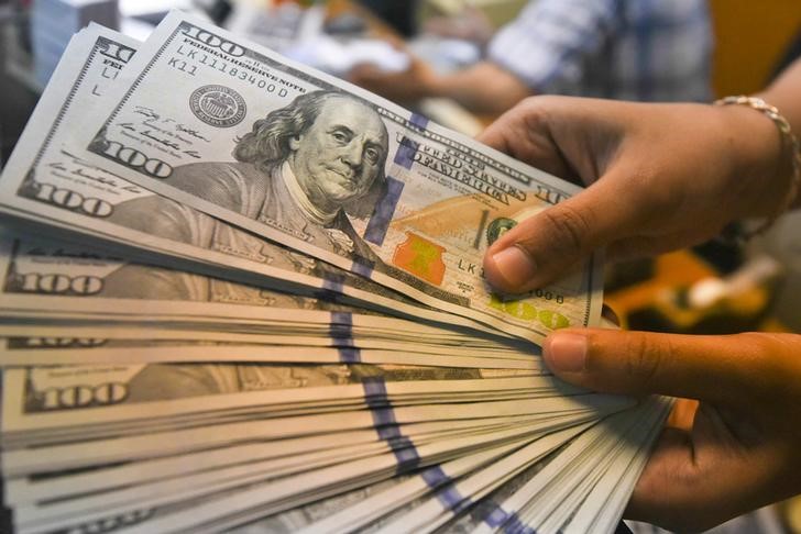 © Reuters. An employee shows U.S. dollars banknotes at a money changer in Jakarta