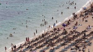 © Reuters. Tourists sunbathe and swim at the beach of Magaluf on the island of Mallorca