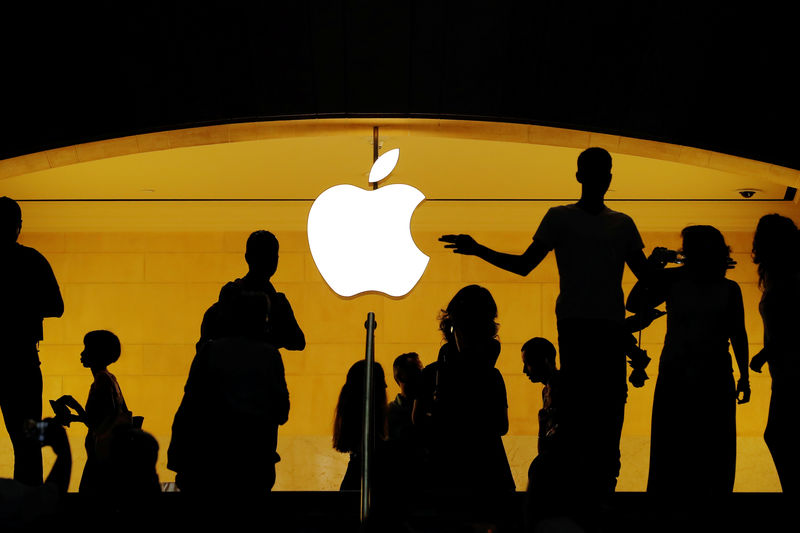 © Reuters. Clientes pasan frente al logo de Apple en una tienda de la empresa en Nueva York