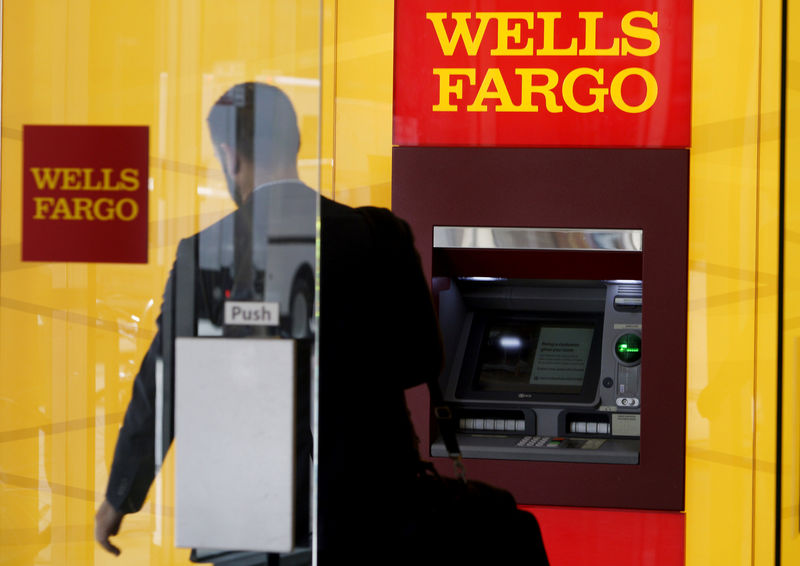 © Reuters. FILE PHOTO: A man walks by an ATM at the Wells Fargo & Co. bank in downtown Denver