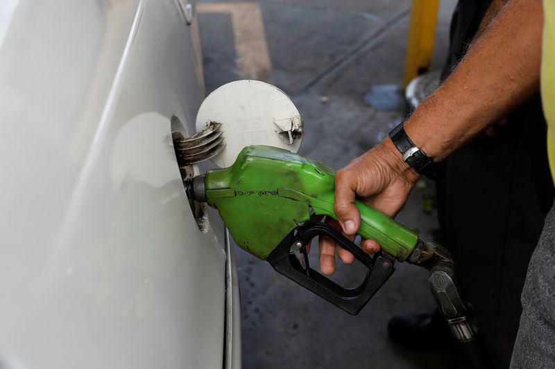 © Reuters. A man pumps gas into his car at a gas station in Caracas