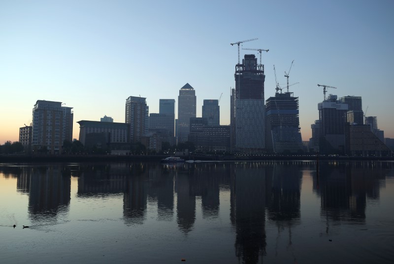 © Reuters. FILE PHOTO: The Canary Wharf financial district is reflected in the river Thames on a sunny morning in London