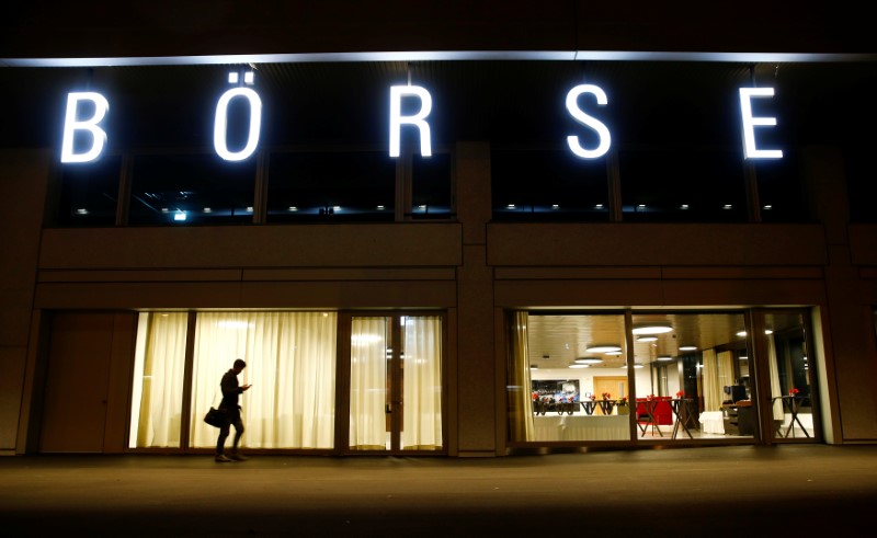 © Reuters. A man walks under the illuminated word "Borse" as he passes the headquarters of stock exchange operator SIX Group in Zurich