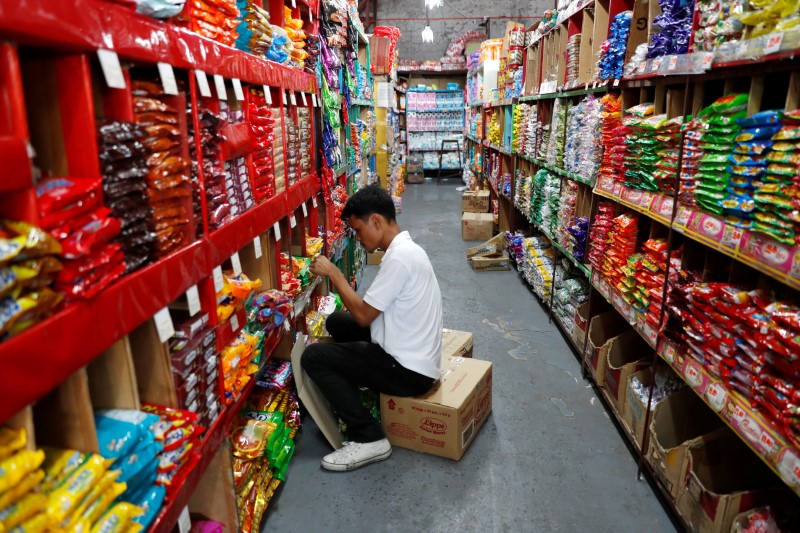 © Reuters. A worker sorts grocery items at a supermarket in Las Pinas