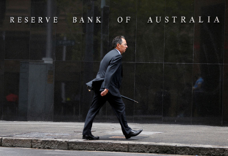 © Reuters. FILE PHOTO A businessman walks past the Reserve Bank of Australia in Sydney