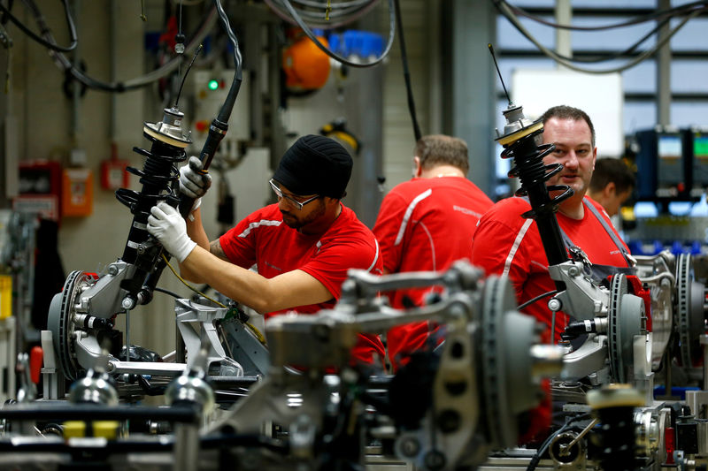 © Reuters. FILE PHOTO: Employees of German car manufacturer Porsche work chassis at the Porsche factory in Stuttgart-Zuffenhausen