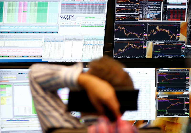 © Reuters. FILE PHOTO: A trader sits in front of the computer screens at his desk at the Frankfurt stock exchange