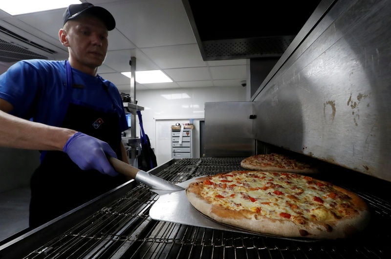 © Reuters. FILE PHOTO: A staff member prepares pizzas at a Domino's Pizza restaurant in Moscow