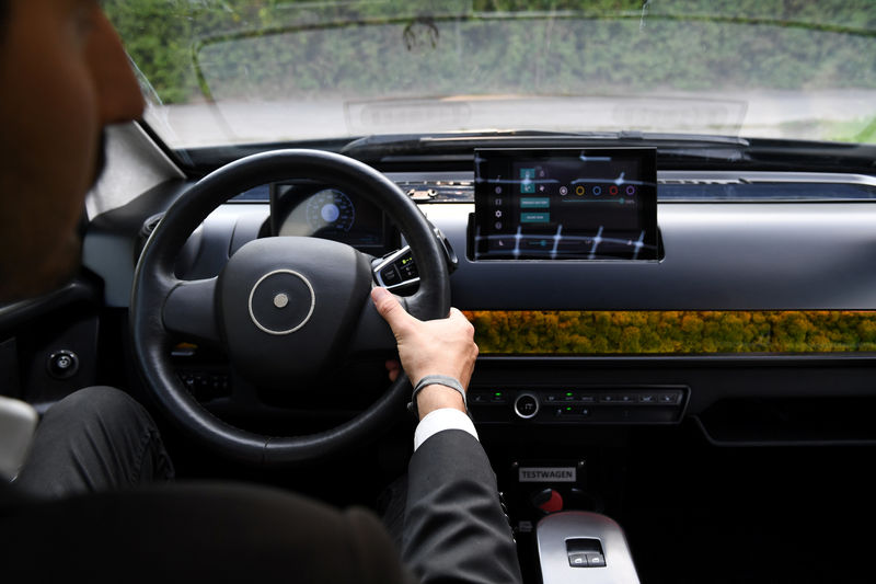 © Reuters. An employee of German solar car company Sono Motors holds the steering wheel of the prototype car "Sion" in Munich