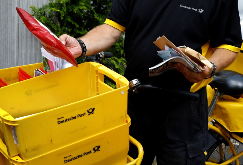 © Reuters. A postman of German mail services Deutsche Post AG delivers mail in Hanau
