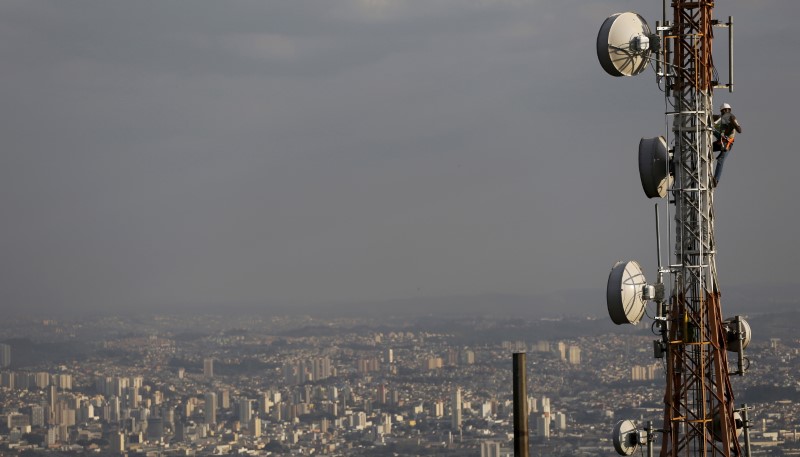 © Reuters. Homem trabalha em uma torre com vários tipos de antenas direcionais em São Paulo