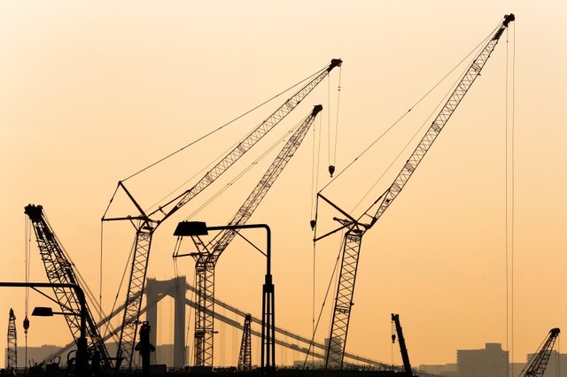 © Reuters. Cranes are pictured against sunset at a construction site in Tokyo