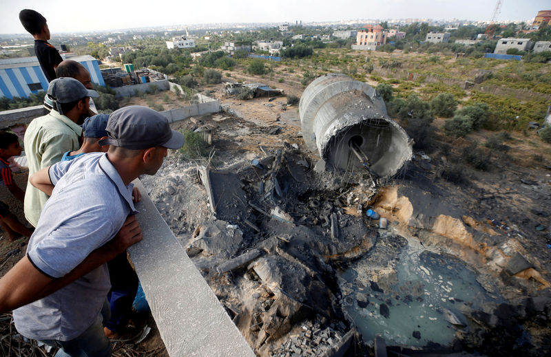 © Reuters. Palestinians look at damage at the site of an Israeli air strike in Al-Mughraqa on the outskirts of Gaza City