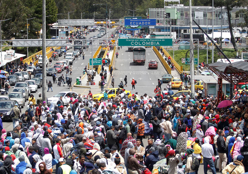 © Reuters. Venezuelan migrants stand in line to register their exit from Colombia before entering into Ecuador,  at the Rumichaca International Bridge