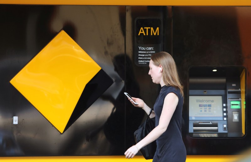 © Reuters. A woman walks past a Commonwealth Bank of Australia logo in Sydney