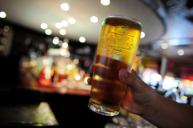 © Reuters. FILE PHOTO: A customer poses for the camera with a pint of beer in a public house in Leeds, northern England