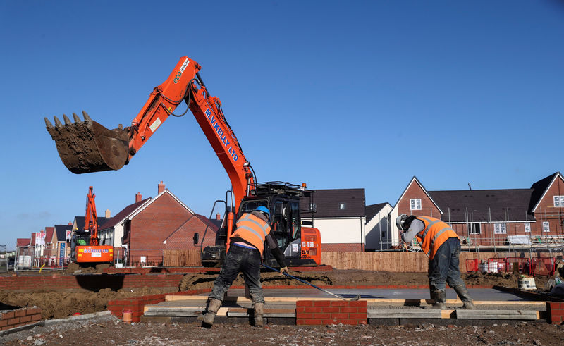 © Reuters. FILE PHOTO: Construction workers work on a Taylor Wimpey housing estate in Aylesbury