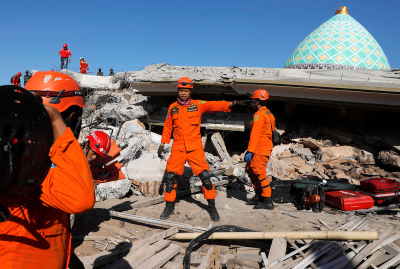 © Reuters. Equipes de resgate buscam pessoas presas sob escombros de mesquita destruída por terremoto em Lombok, na Indonésia