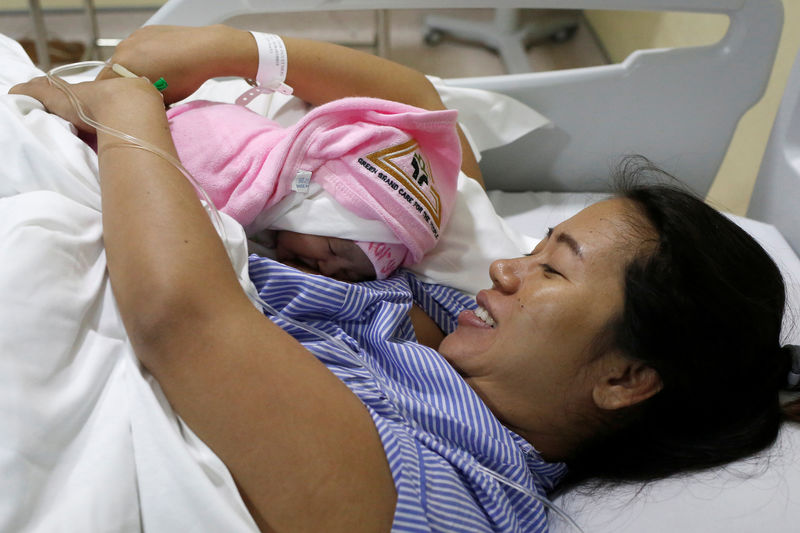 © Reuters. Pan Ei Mon, mulher de jornalista da Reuters detido em Mianmar Wa Lone, abraçada com filha do casal em hospital de Yangon