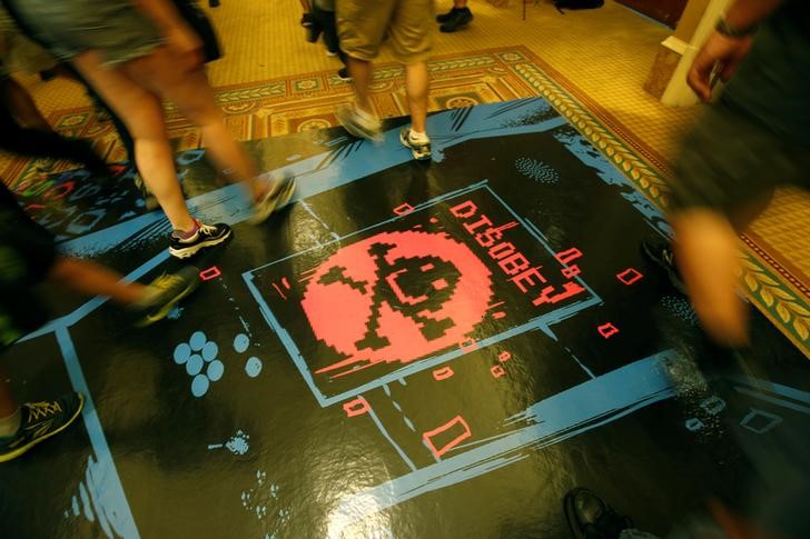 © Reuters. Pessoas passam por cima de ilustração durante convenção de hackers Def Con em Las Vegas, Nevada