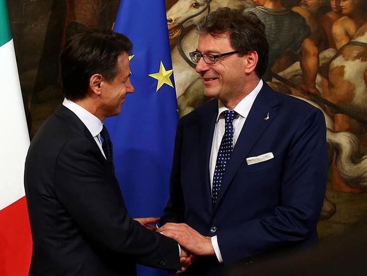 © Reuters. FILE PHOTO: Newly appointed Italian Prime Minister Giuseppe Conte shakes hands with undersecretary for Prime Minister Giancarlo Giorgetti at Chigi palace in Rome