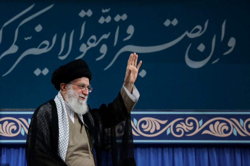 © Reuters. Libano, una donna mostra una foto col volto dell'Ayatollah Alì Khamenei , suprema autorità dell'Iran