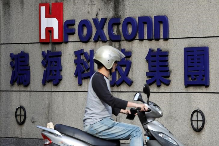 © Reuters. Homem passa por logo da Foxconn, em Taipé, Taiwan