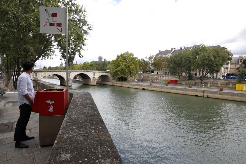 © Reuters. Jornalista posa para foto em frente a mictório na ilha de Saint-Louis, na margem do Rio Sena, em Paris