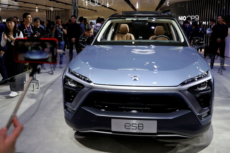 © Reuters. FILE PHOTO: Visitors check NIO ES8 displayed during a media preview of the Auto China 2018 motor show in Beijing