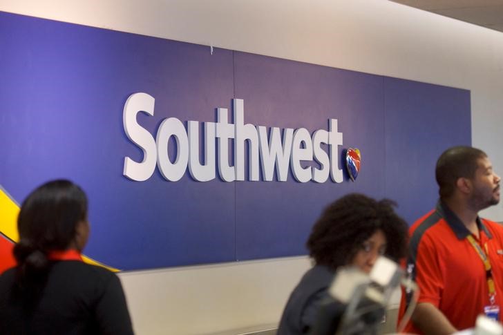 © Reuters. A Southwest Arlines logo is seen as employees check in travelers at the Philadelphia International Airport