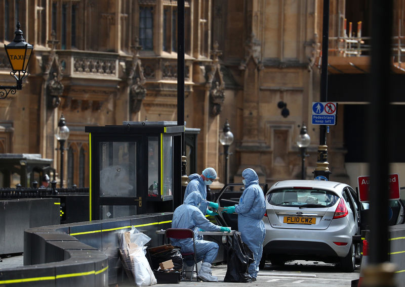 © Reuters. Investigadores trabalham no local de ataque com carro do lado de fora do Parlamento britânico, em Londres