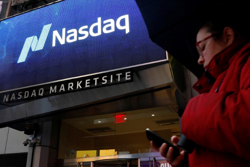© Reuters. FILE PHOTO: A woman passes by the Nasdaq Market Site in Times Square in New York