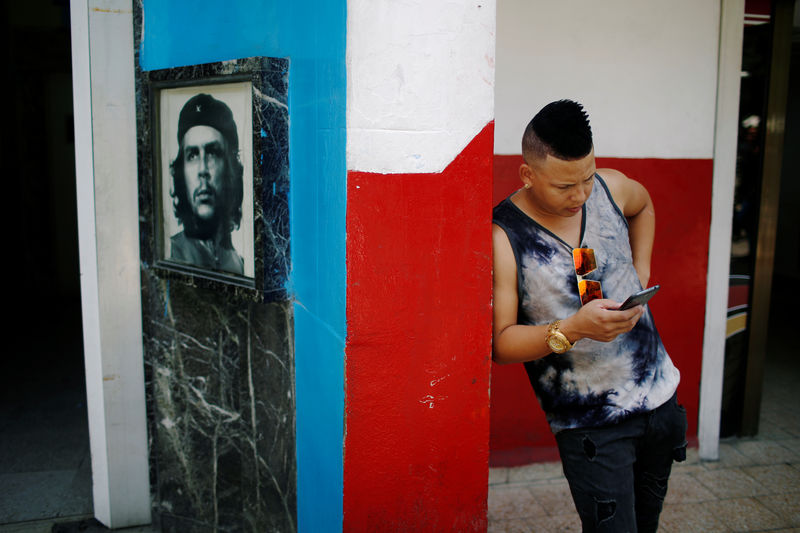 © Reuters. Cubano olha telefone celular em local de conexão à internet em Havana