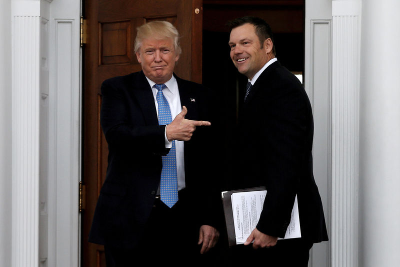 © Reuters. FILE PHOTO: U.S. President-elect Trump stands with Kansas Secretary of State  Kobach before their meeting at Trump National Golf Club in Bedminster
