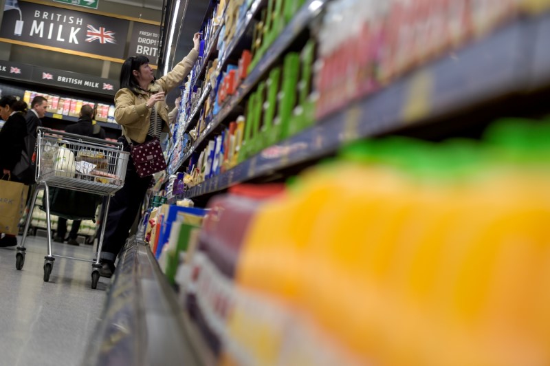 © Reuters. FILE PHOTO: A shopper reaches to a high shelf in an Aldi store in London