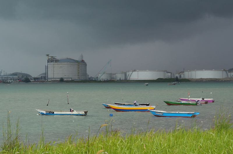 © Reuters. FILE PHOTO: Boats float in front of the VOPAK oil storage terminal in Johor