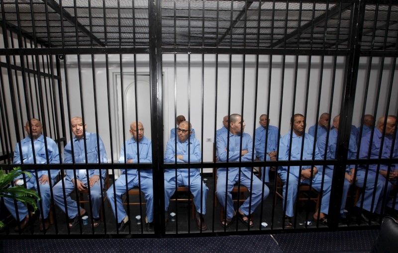 © Reuters. Imagen de archivo de exfuncionarios del régimen de Muammar Gaddafi sentados tras las rejas durante una audiencia de veredicto en una corte en Trípoli