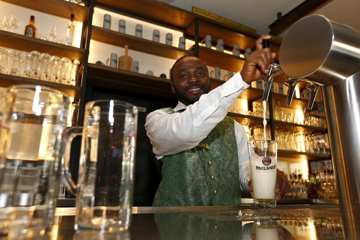 © Reuters. File photo of Abbey from Sierra Leone posing while working as waiter in restaurant called 'Muenchner Stuben' in Munich