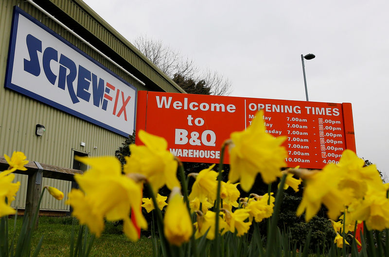 © Reuters. FILE PHOTO: Signs for B&Q and Screwfix are seen behind flowers in Loughborough