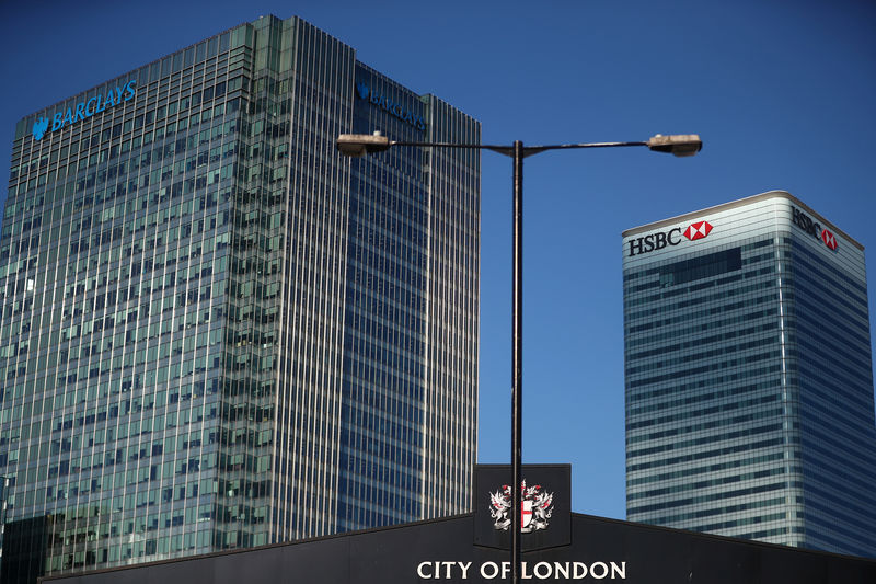 © Reuters. HSBC and Barclays' buildings in Canary Wharf are seen behind a City of London sign outside Billingsgate Market in London