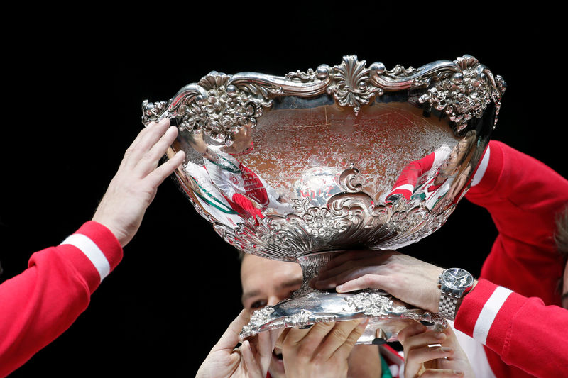 © Reuters. FILE PHOTO: The hands of Switzerland's team members hold the Davis Cup trophy after winning the Davis Cup tennis tournament final match against France at the Pierre-Mauroy stadium in Villeneuve d'Ascq